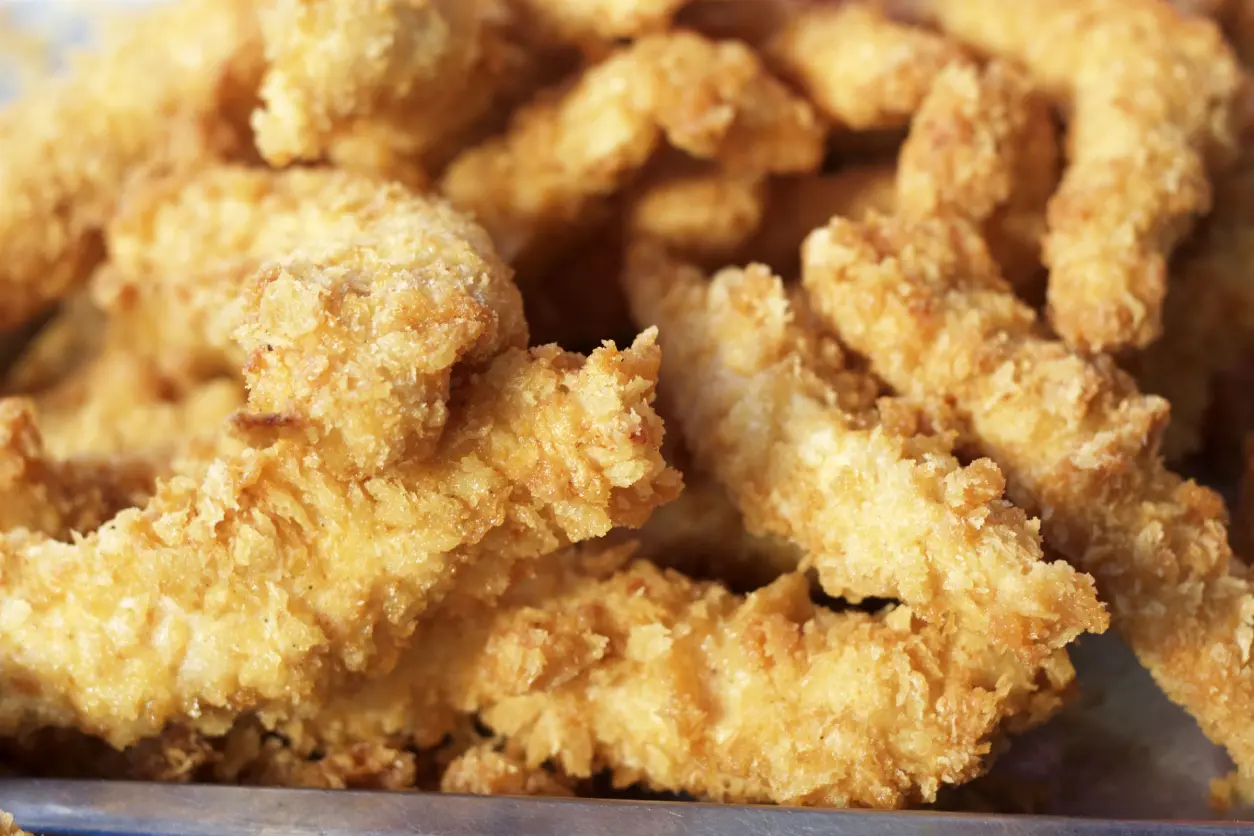 New Project(1) Close-up of crispy, golden-brown fried chicken tenders piled together.